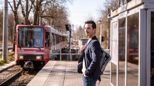 Mann steht an Bahnsteig