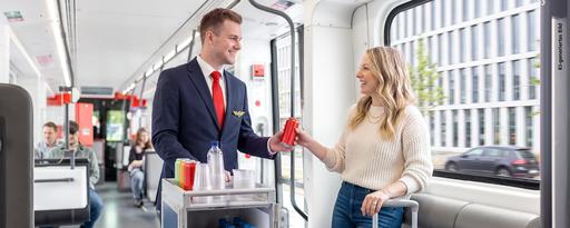 Frau und Mann in Stadtbahn mit Getränkewagen (Bild KI-generiert)